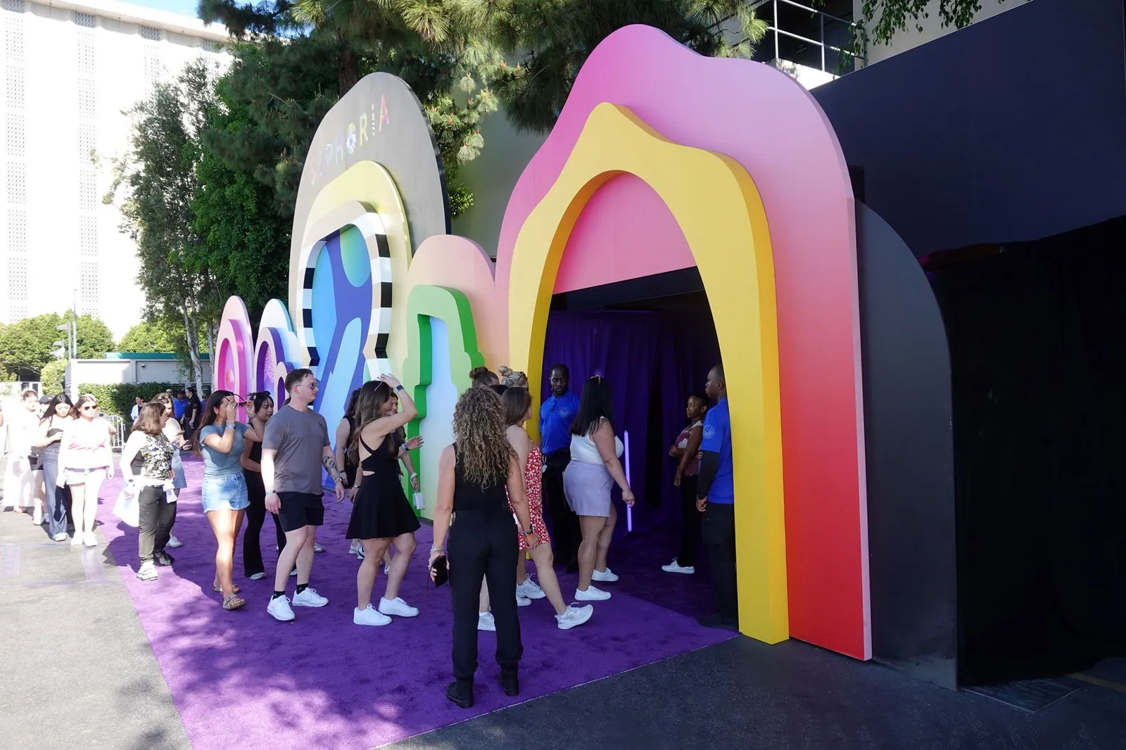 Guests lining up under rainbow arches at an outdoor activation
