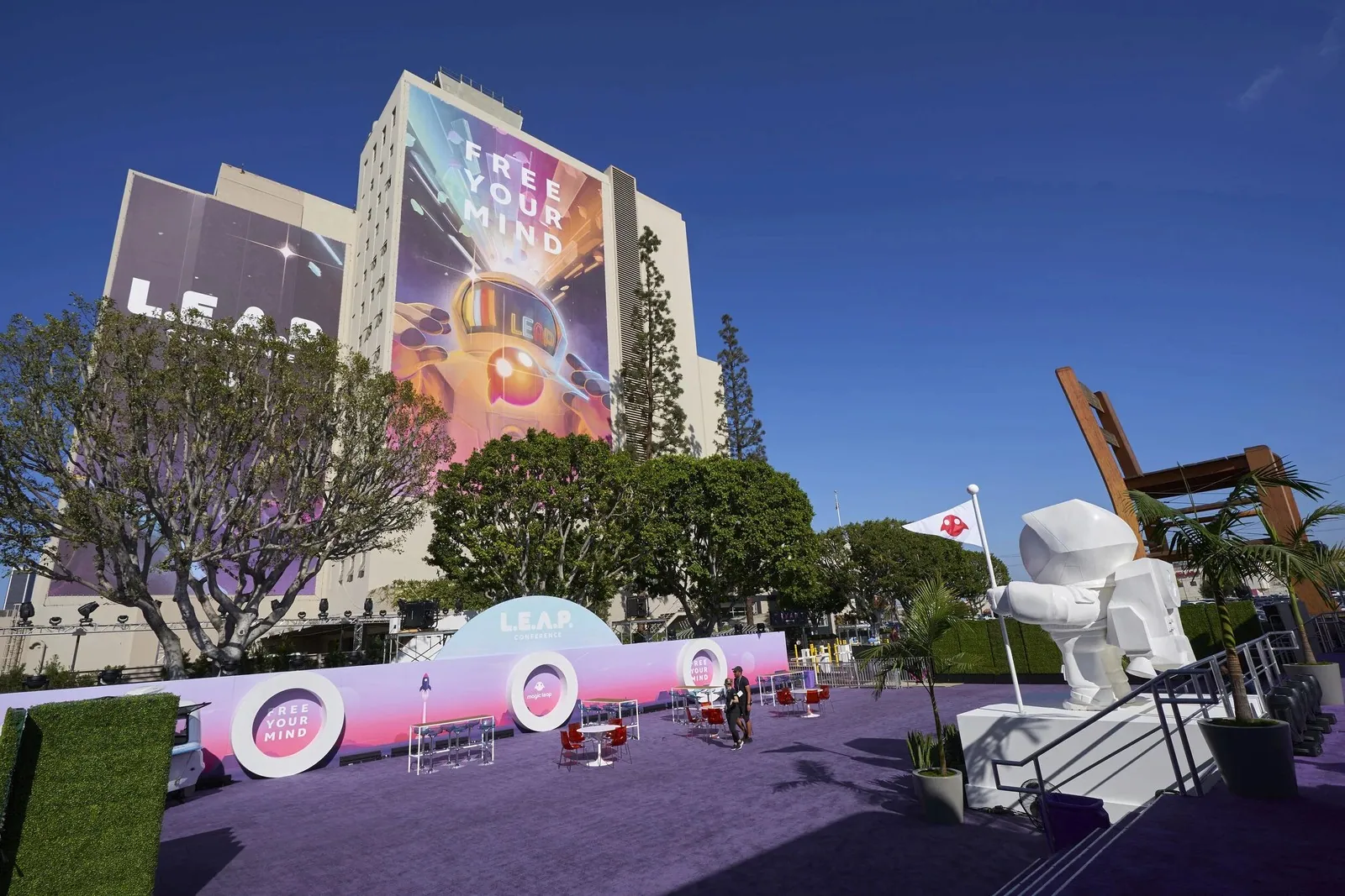 An outdoor activation plaza under a painted building mural
